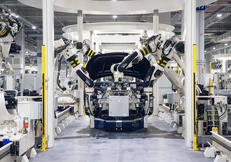 Robotic arms working on a car body on an automated assembly line
