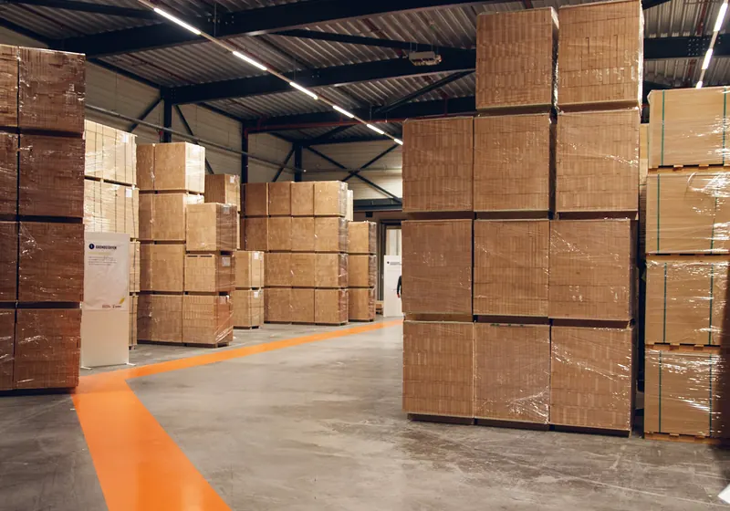 Stacks of shrink-wrapped cardboard boxes on pallets in a warehouse