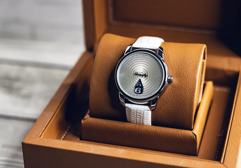 Wristwatch on a cushion in an open leather presentation box